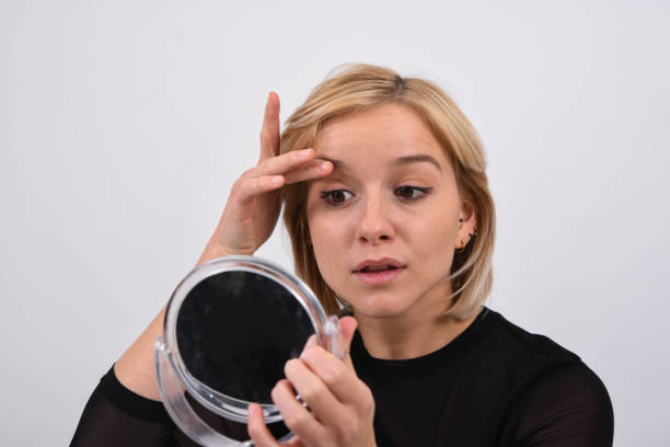 Close-up of a woman using under-eye powder to prevent mascara smudging
